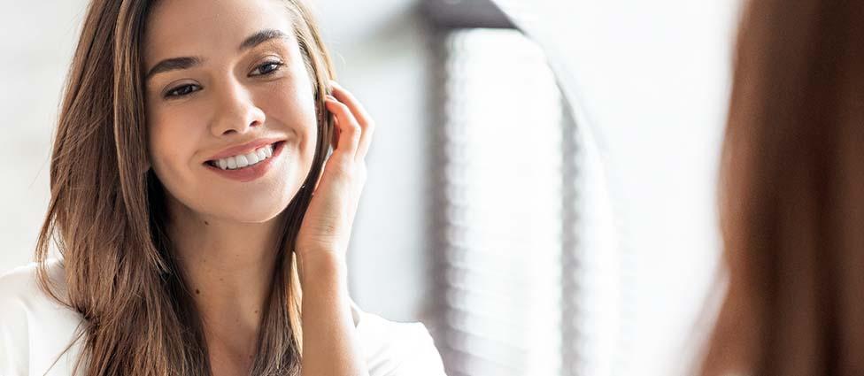 Woman looking at smile in mirror