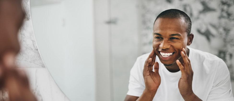 Man looking at teeth in mirror